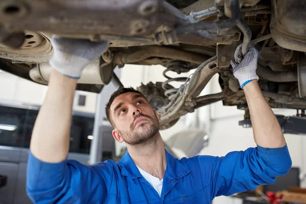 Mechaniker oder Schmied reparieren Auto in der Werkstatt - Stockfotografie:  lizenzfreie Fotos © Syda_Productions 130704196