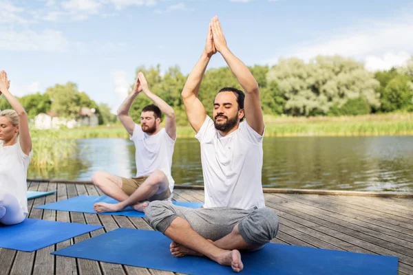 Personas meditando en yoga loto posan al aire libre — Foto de Stock