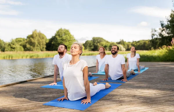 Groep mensen die buiten yoga oefeningen doen — Stockfoto