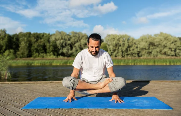 Человек делает yoga в маштабе представления на открытом воздухе — стоковое фото