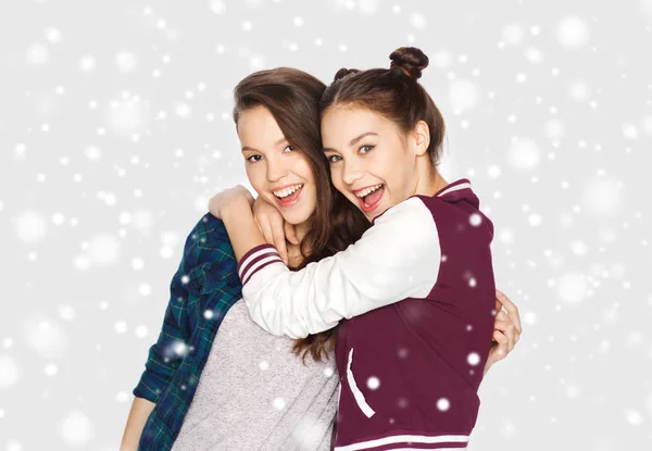 Счастливые улыбающиеся девочки-подростки, обнимающиеся по снегу — стоковое фото