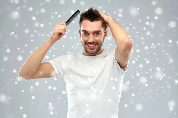 Homme heureux brossant les cheveux avec peigne sur la neige — Photo