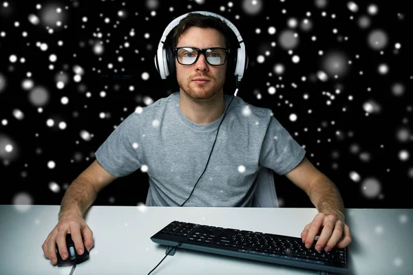 Hombre en auriculares jugando videojuego de ordenador — Foto de Stock