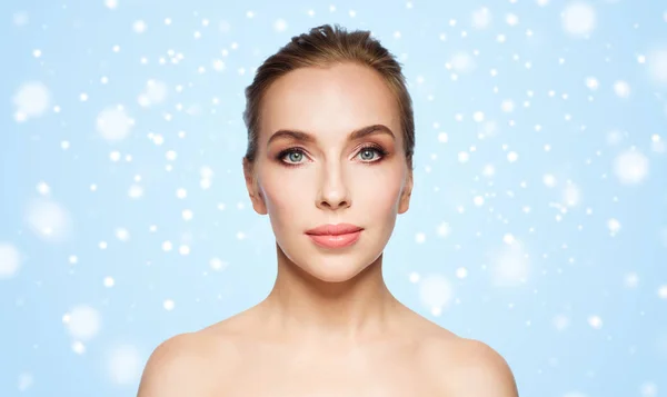 Beautiful young woman face over snow — Stock Photo, Image