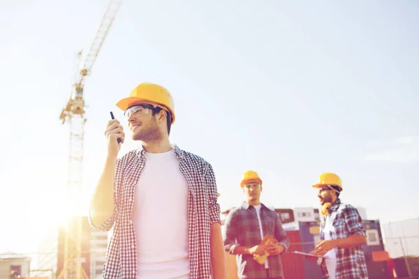 Grupo de constructores sonrientes en sombreros con radio — Foto de Stock