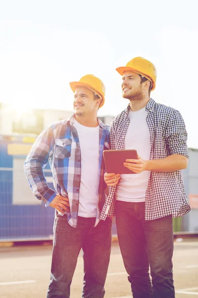 Smiling builders with tablet pc outdoors — Stock Photo, Image