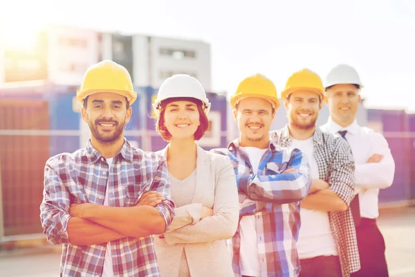 Gruppo di costruttori sorridenti in hardhats all'aperto — Foto Stock