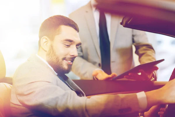 Homem feliz com negociante de carro em auto show ou salão de beleza — Fotografia de Stock