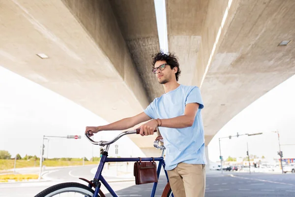 Hipster-Mann mit Fahrrad mit festem Gang unter Brücke — Stockfoto