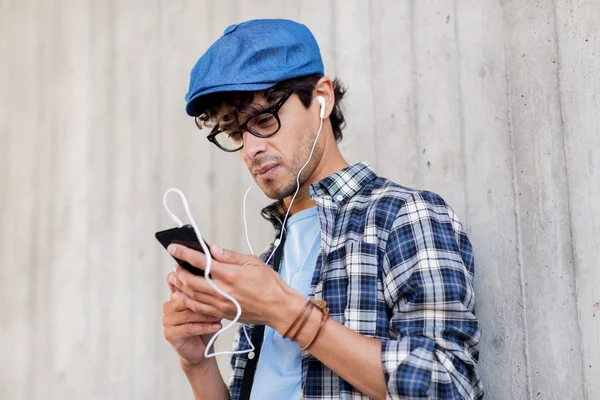 Человек с наушниками и смартфоном слушает музыку — стоковое фото