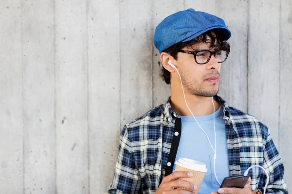 Hombre con auriculares y teléfono inteligente beber café —  Fotos de Stock