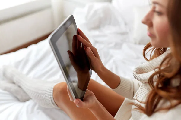Молодая женщина с планшетным компьютером в постели дома — стоковое фото
