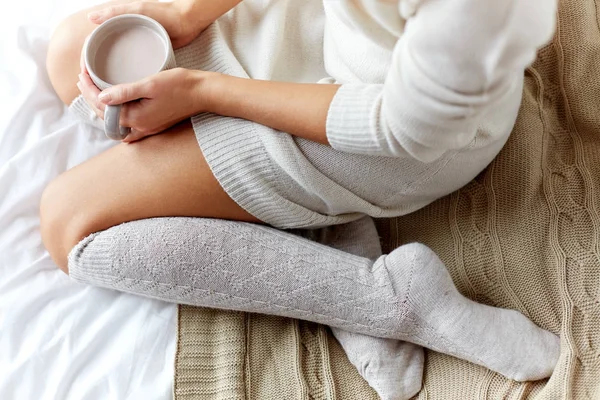 Close up of woman with cocoa cup in bed at home — Stock Photo, Image