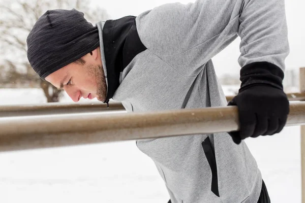 겨울에 평행 봉에서 운동 하는 젊은 남자 — 스톡 사진
