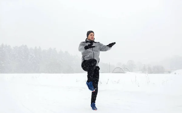 Mann trainiert und wärmt sich im Winter im Freien auf — Stockfoto