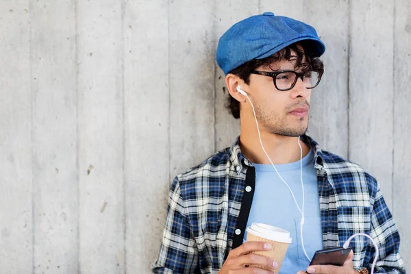 耳机和智能手机喝咖啡的人 图库照片