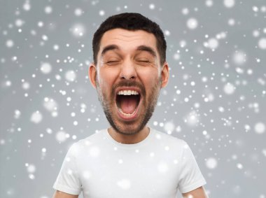 crazy shouting man in t-shirt over snow background clipart