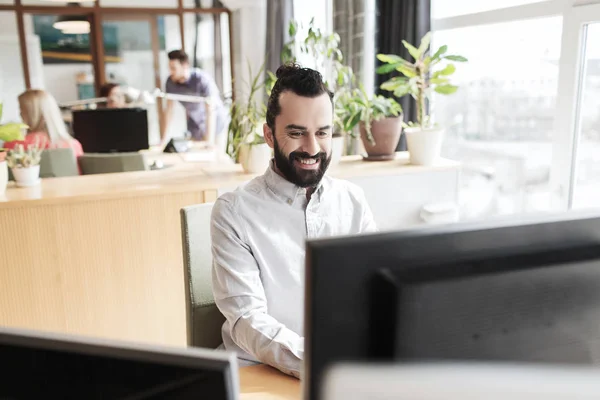 Happy creative male office worker with computer — Stock Photo, Image