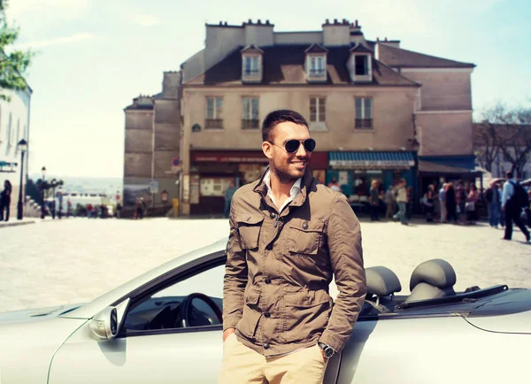 Happy man driving cabriolet car over city — Stock Photo, Image