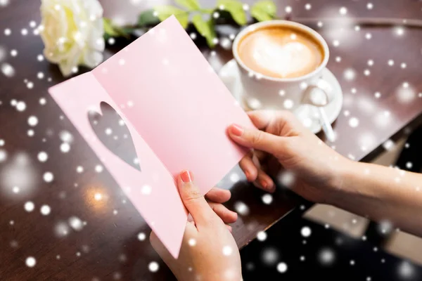 Close up of woman reading greeting card and coffee — Stock Photo, Image