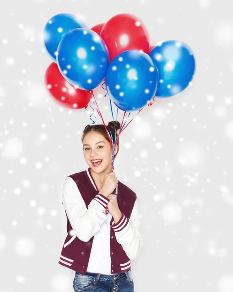 Ευτυχισμένος κορίτσι εφηβικής με μπαλόνια ηλίου πάνω από το χιόνι Royalty Free Φωτογραφίες Αρχείου