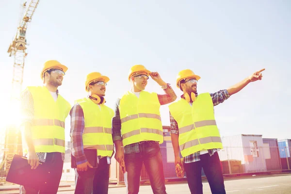 Группа улыбающихся строителей с планшетным ПК на открытом воздухе — стоковое фото