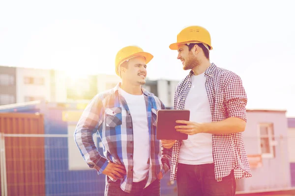 Constructores sonrientes en sombreros con tablet pc —  Fotos de Stock