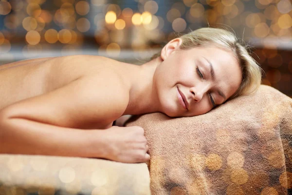 Ung kvinna ligga på massagebänk i spa — Stockfoto