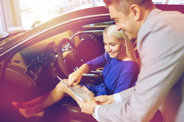 Mulher feliz com negociante de carro em auto show ou salão de beleza — Fotografia de Stock