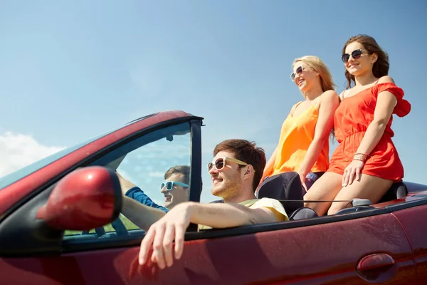 Amigos felizes dirigindo em carro cabriolet — Fotografia de Stock