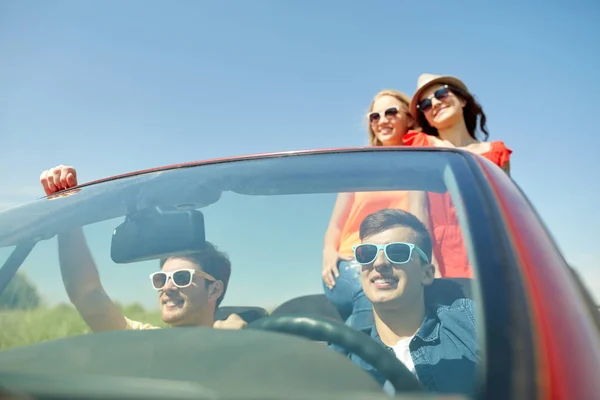 Amigos felices conduciendo en coche cabriolet — Foto de Stock