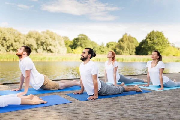 Groep mensen die buiten yoga oefeningen doen — Stockfoto