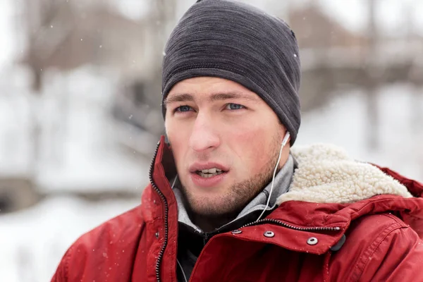 Man with earphones listening to music in winter — Stock Photo, Image