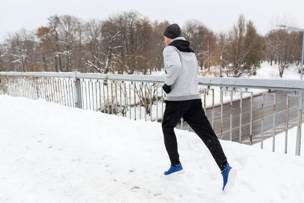Ο άνθρωπος στα ακουστικά που τρέχει κατά μήκος της γέφυρας του χειμώνα — Φωτογραφία Αρχείου