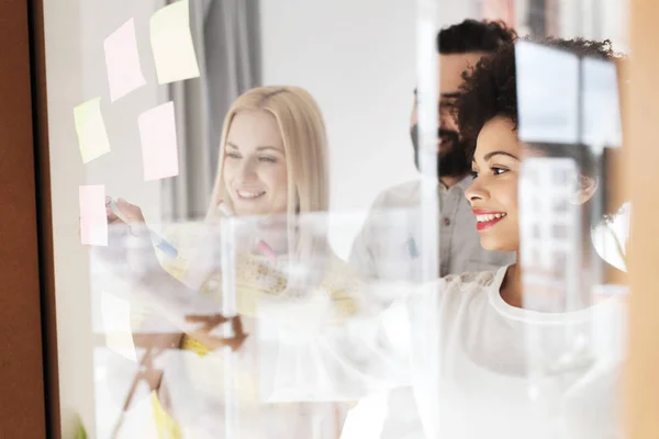 Glückliches Kreativ-Team schreibt auf Aufkleber im Büro — Stockfoto