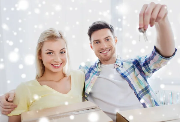 Happy couple with key and boxes moving to new home — Stock Photo, Image