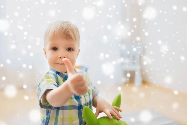 Mutlu bebek çocuk oyuncak başparmak göstermek yukarıya ile oynarken — Stok fotoğraf