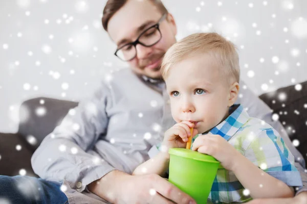 Padre e hijo bebiendo de la taza en casa — Foto de Stock