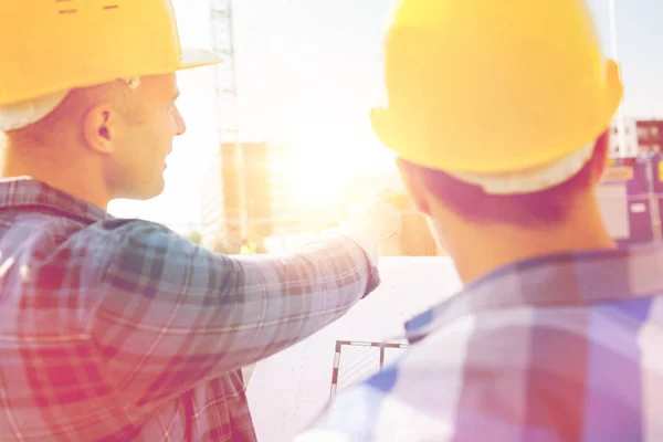 Primer plano de los constructores con plano en el edificio — Foto de Stock