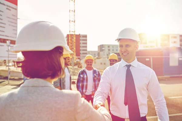 Byggare att göra handslag på byggarbetsplats — Stockfoto