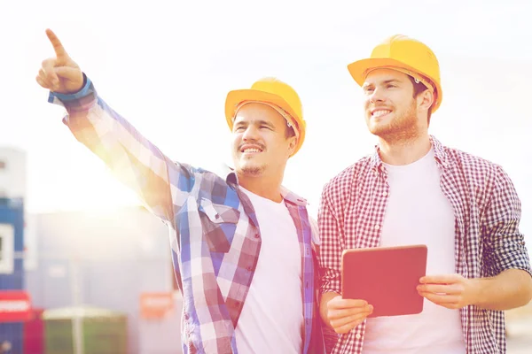 Smiling builders in hardhats with tablet pc — Stock Photo, Image