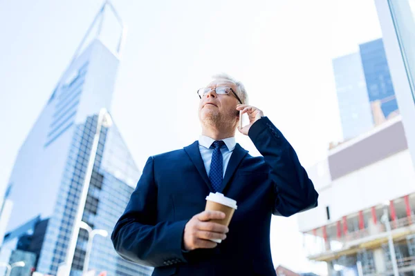 Senior businessman volá na smartphone ve městě — Stock fotografie