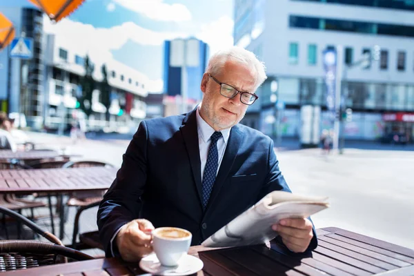 コーヒーを飲みながら新聞を持つ上級ビジネスマン — ストック写真
