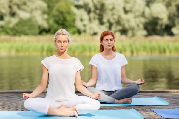 Donne che meditano in yoga loto posa all'aperto — Foto Stock