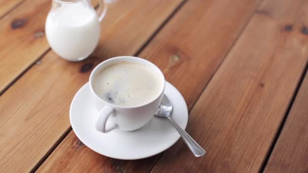 Mão deixando cair açúcar na xícara de café na mesa — Vídeo de Stock