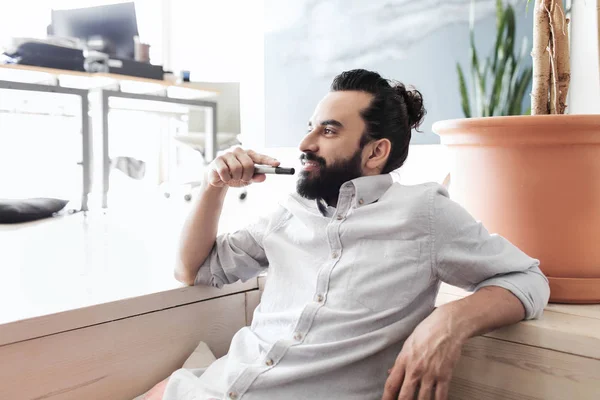 Uomo sorridente con barba e capelli panino in ufficio — Foto Stock