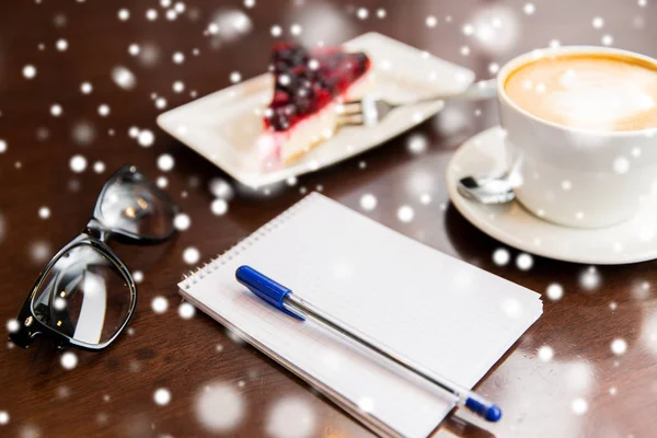 Nahaufnahme von Notizbuch mit Stift, Kaffeetasse und Kuchen — Stockfoto