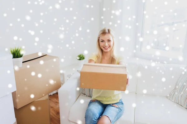 Giovane donna sorridente con scatola di cartone a casa — Foto Stock