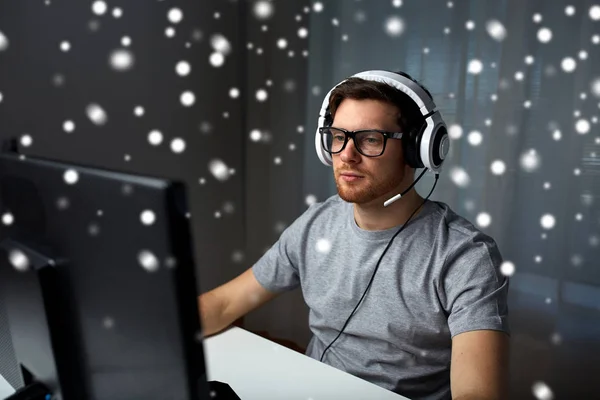 Muž v sluchátka hrát počítačové video hru doma — Stock fotografie