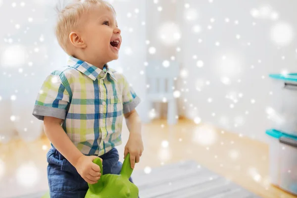 Fröhlicher kleiner Junge spielt zu Hause mit Aufsitzspielzeug — Stockfoto